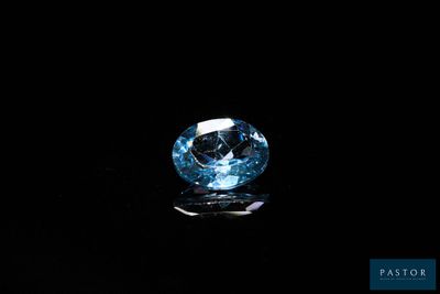 gros plan d'un diamant bleu sur une surface noire