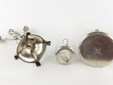 three pieces of silverware including a teapot, a tea kettle, and a spoon