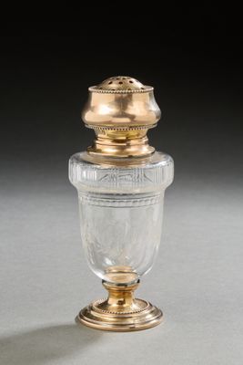 an old fashioned glass jar with a gold lid on a table