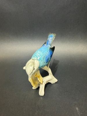 a figurine of a bird sitting on a branch