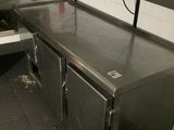 a large stainless steel counter in a kitchen with a sink