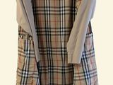 beige and black plaid dress hanging on a hanger on a white wall