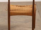 a close up of a wooden chair with a woven seat