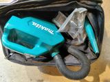 a blue blow dryer in a black bag on the floor