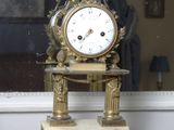 a clock that is sitting on a table in front of a window