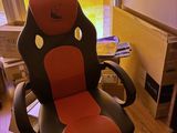 une chaise de bureau rouge et noire placée devant une fenêtre