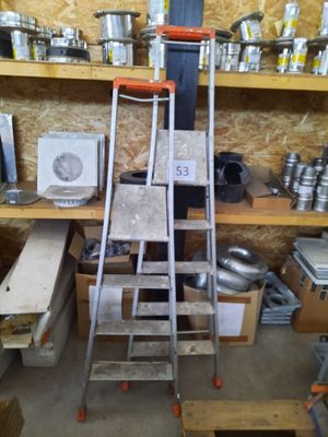 a ladder that is next to a shelf with pots and pans on it