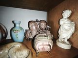 a shelf that has a lot of vases and statues on it