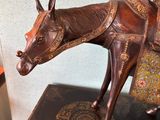 a statue of a horse with a saddle on top of a table