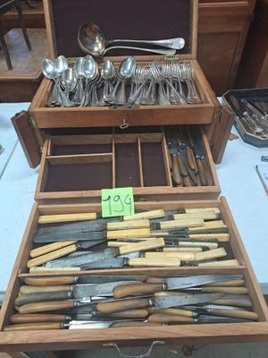 de nombreux types de couteaux et de cuillères dans une boîte en bois