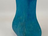 a blue vase that is sitting on a white surface