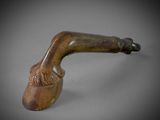 a close up of a pipe on a table with a gray background