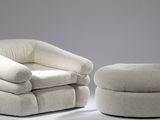 une chaise blanche et un pouf dans une pièce
