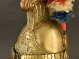 a gold helmet with a feather on top of it