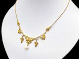 a white mannequin with a gold necklace on it