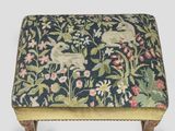 an upholstered footstof with a floral design on a blue background