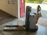 a fork lifter sitting on the floor in front of a red door