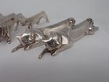 several silver metal animal figurines on a white surface