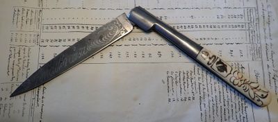 un couteau posé sur une feuille de papier