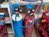 two propane gas bottles and a hose in a garage