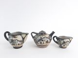 three pieces of pottery sitting on a white surface