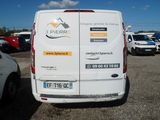 a white van parked in a parking lot with other cars