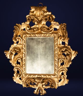 un cadre doré richement décoré, avec un miroir sur fond bleu