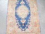 un tapis persan ancien, avec une bordure bleue et un motif floral