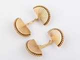 a pair of gold cufflinks with fan shaped shells