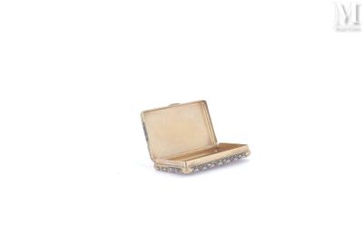 une petite valise ouverte posée sur une surface blanche
