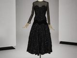 une robe noire posée sur un mannequin dans une pièce blanche