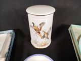 a white plate with a bird on it next to a blue and white bowl