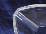 a close up of a clear glass bowl on a blue cloth