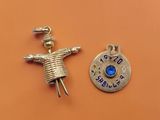 a close up of a small silver charm with a blue stone