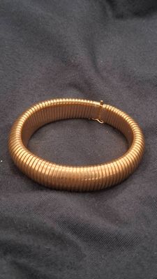 gold plated bracelet on a black cloth with a gold clasp