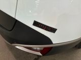 the rear end of a white car with a sticker on it