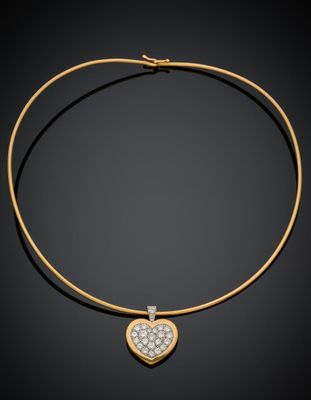 un collier en or avec un pendentif en forme de cœur serti d'un diamant