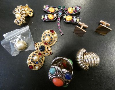 a lot of jewelry on a table with a bag