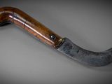 a close up of a knife with a wooden handle on a table