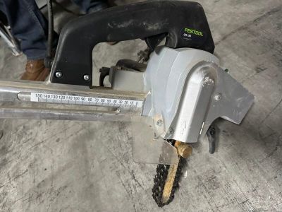 une personne qui utilise une tronçonneuse pour couper un morceau de bois