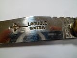 quelqu'un tient un couteau sur lequel est écrit le mot laguile extra