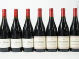 six bouteilles de vin rouge alignées sur une surface blanche
