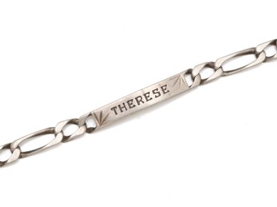 un gros plan d'un bracelet en argent sur lequel est gravé un message