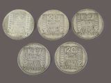 four silver coins with chinese writing on them on a gray background