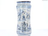 un vase bleu et blanc orné d'une image représentant des personnes