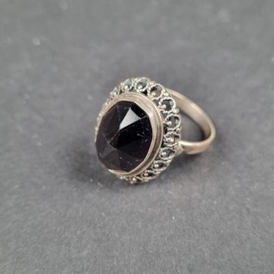 un gros plan d'une bague contenant une pierre noire