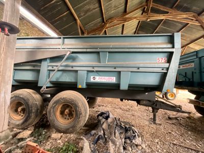un camion-benne bleu garé dans une grange