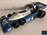a blue and white race car on a white surface