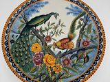 une assiette décorative ornée d'un oiseau et de fleurs