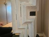 a white sculpture on a black stand in a room